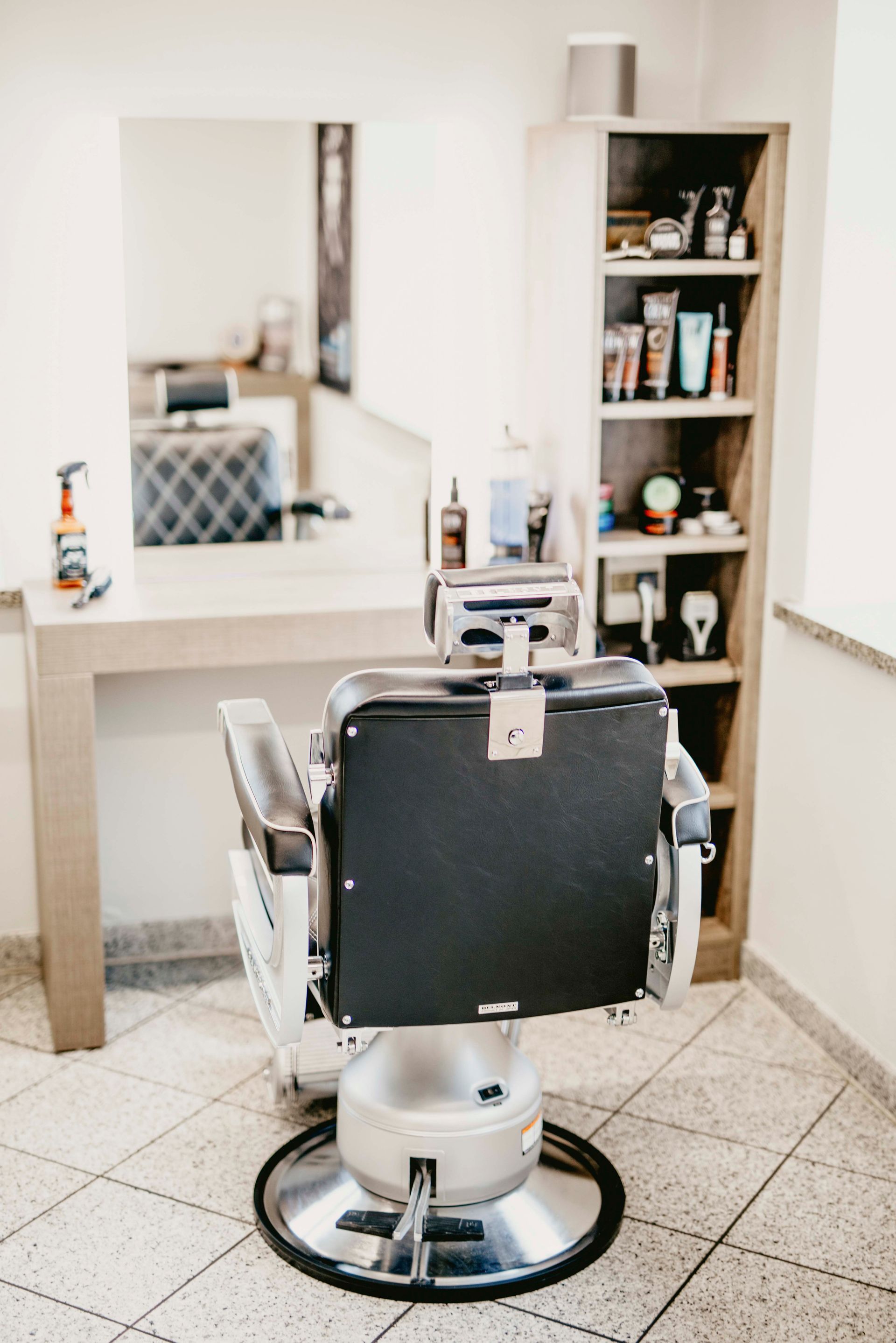 ein Friseurstuhl sitzt in einem Friseursalon neben einem Spiegel