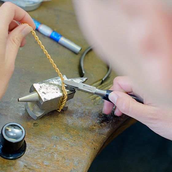 Joaillier réparant les mailles d’un bracelet en or