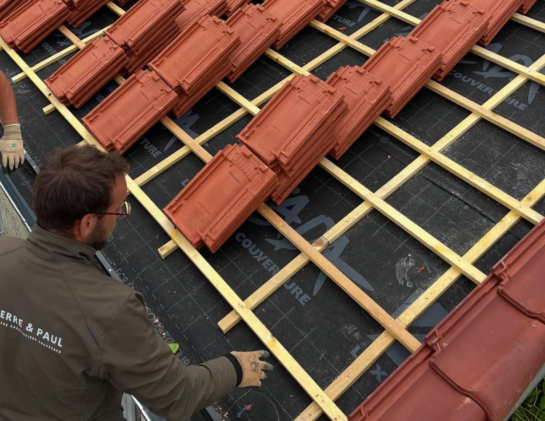Installation de tuiles en cours par deux personnes 