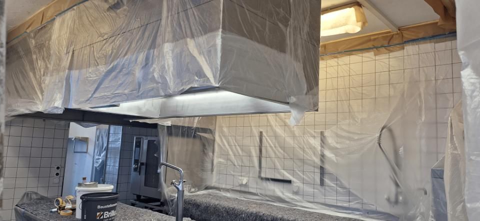 Die Küche wird renoviert; Schränke und Dunstabzugshaube sind mit Plastikfolie abgedeckt.