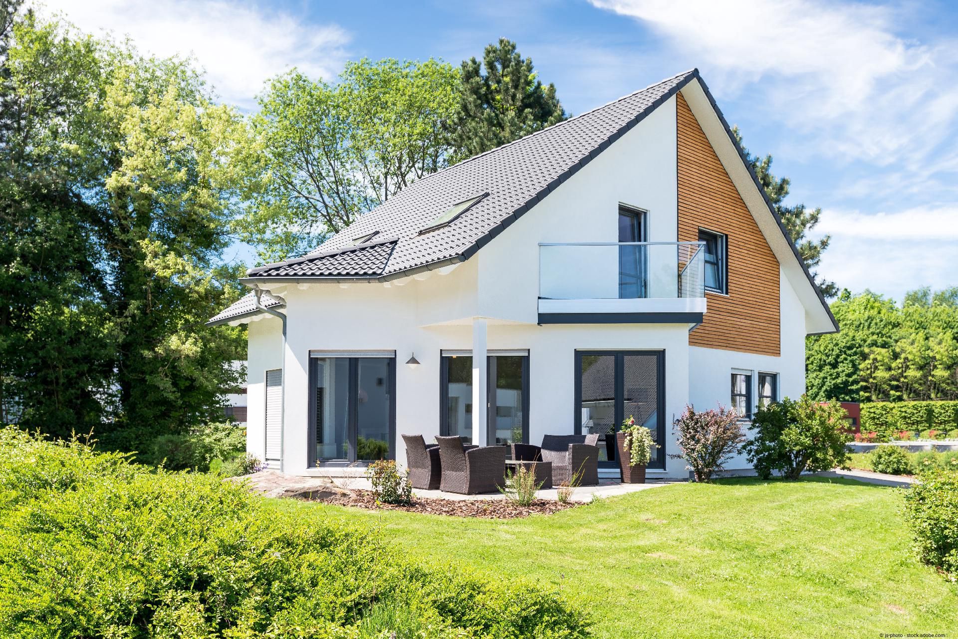 Moderne Hausfassade mit grauen Schiefer­dachziegeln und klaren Linien.