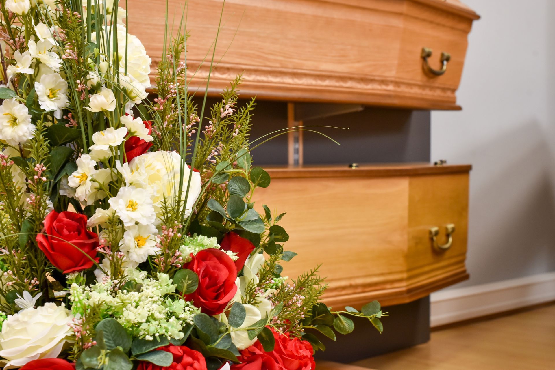 Composition florale près d'un cercueil en bois dans un cadre funéraire