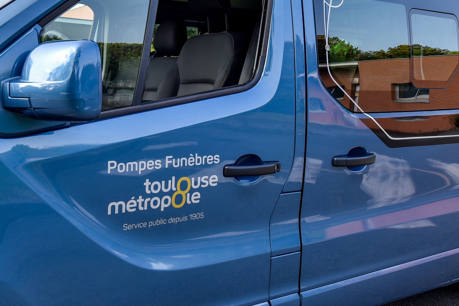 Blue funeral service van with “Pompes Funèbres Toulouse Métropole” logo on the door