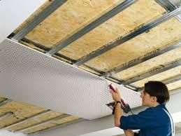 Un hombre está trabajando en el techo de un edificio.