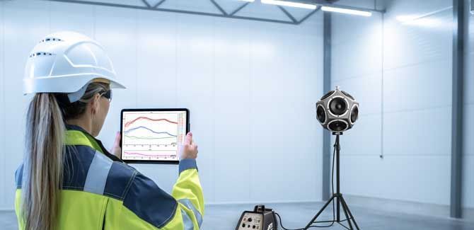 Una mujer con casco mira una tableta en una habitación.