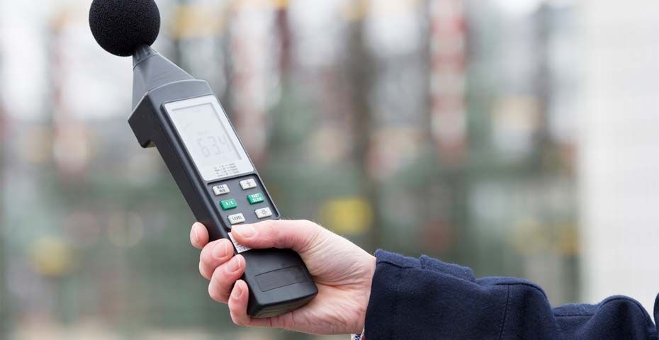 Una persona sostiene un medidor de sonido en su mano.