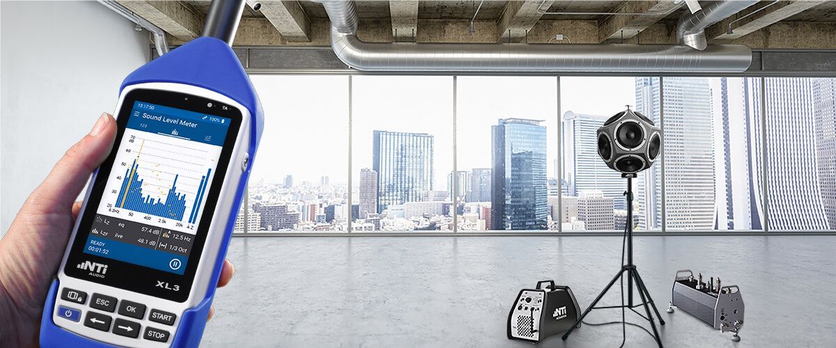 Una persona sostiene un medidor de sonido en una habitación.