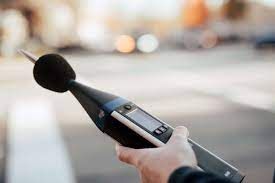 Una persona sostiene un medidor de nivel de sonido en su mano.