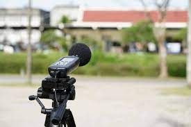 Un micrófono está sentado encima de un trípode en un parque.