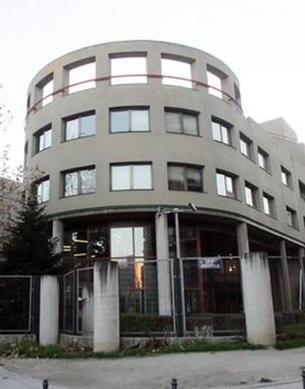 Un edificio con muchas ventanas y una valla alrededor.
