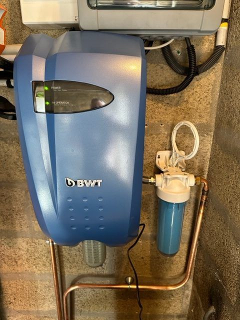 Un petit adoucisseur d'eau bleuté accroché au mur.