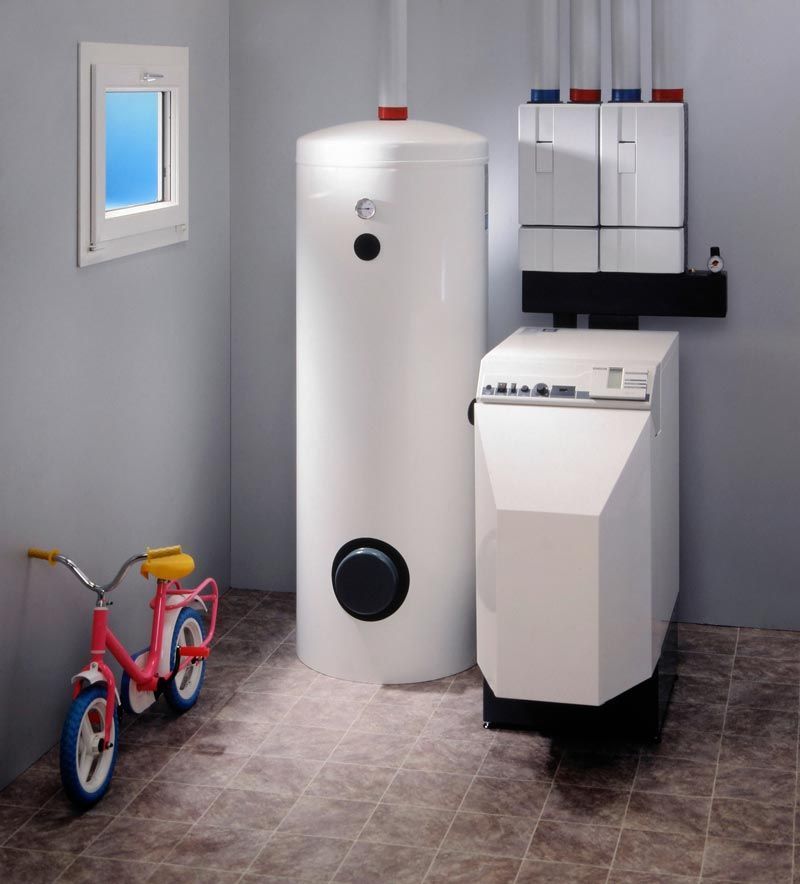 Un vélo pour enfant à côté d'une chaudière à fioul.