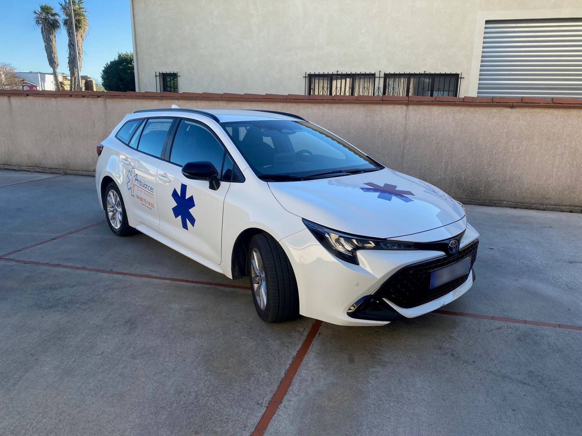 Voitures stationnées devant un bâtiment avec une étoile bleue et portant l'inscription Ambulances Saint-Georges.