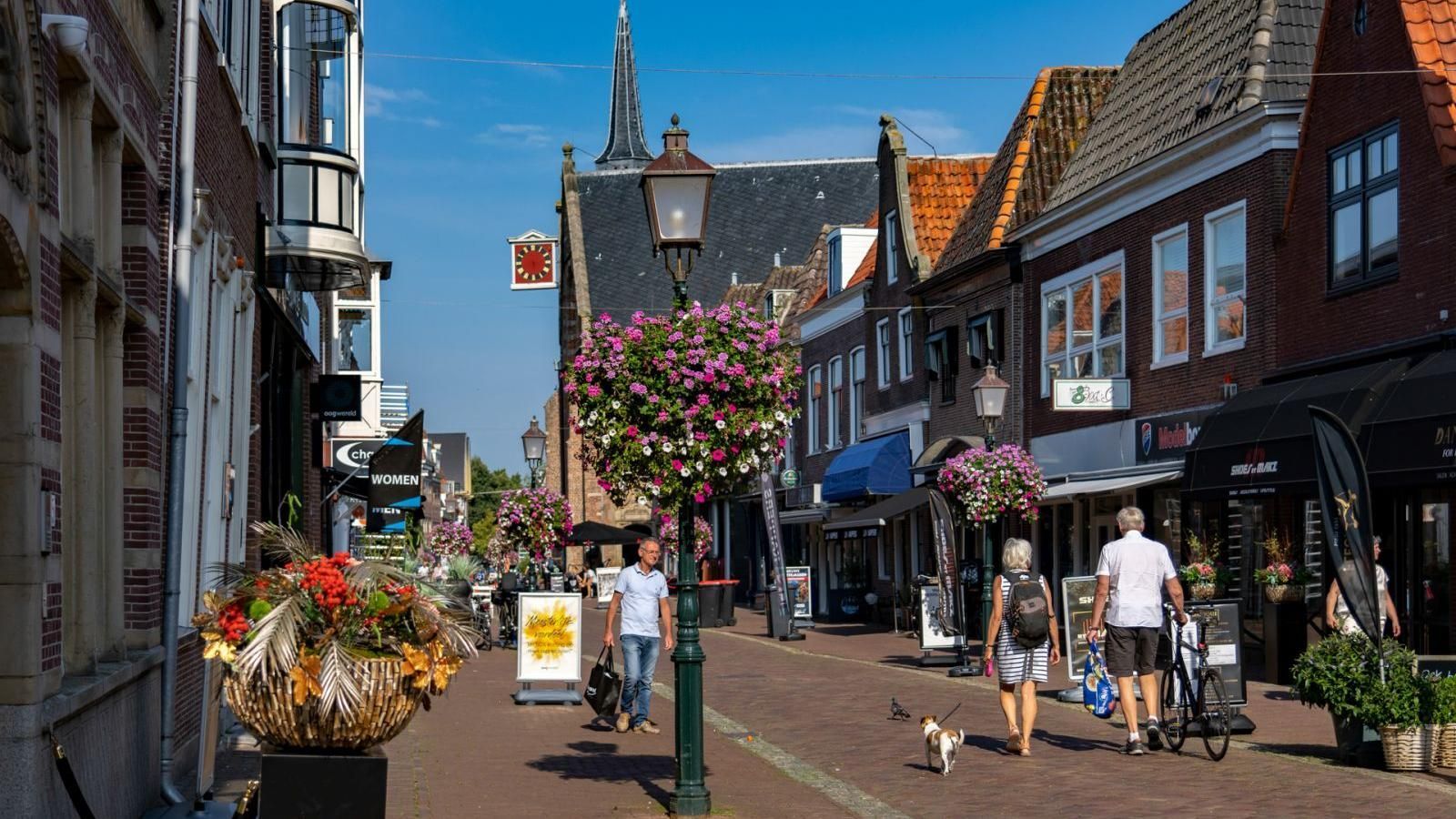 Een groep mensen loopt door een stadsstraat.