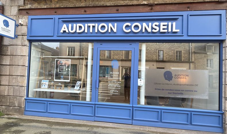 Devanture bleue pour le magasin d'appareils auditifs AUDITION CONSEIL, avec de grandes vitrines et une enseigne.