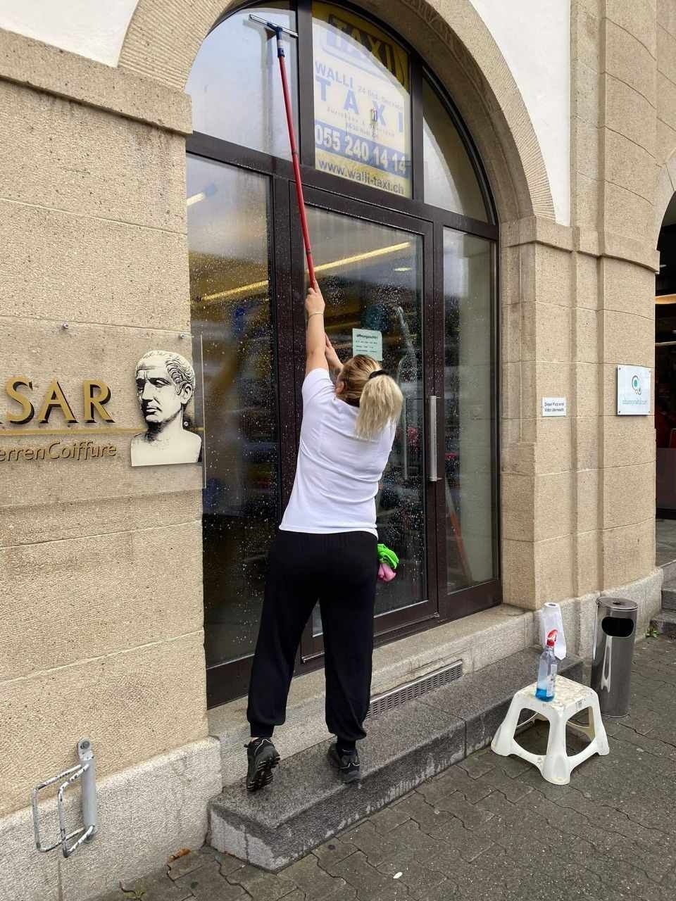 Fachkraft reinigt Fenster