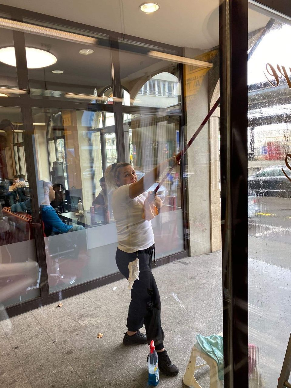 Fachkraft reinigt Fenster