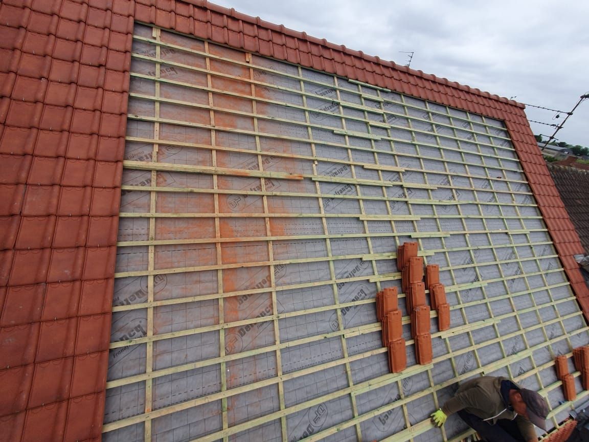 Toiture en tuiles orange avec une sous-couche apparente.