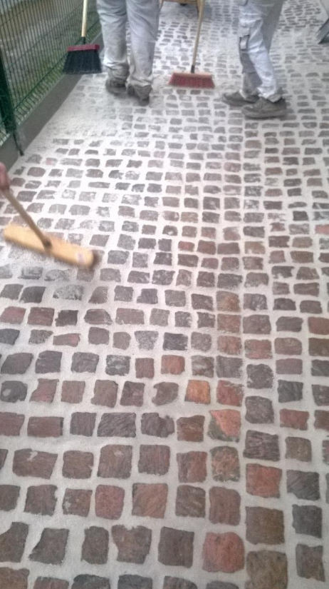 Balai sur une allée en pavé