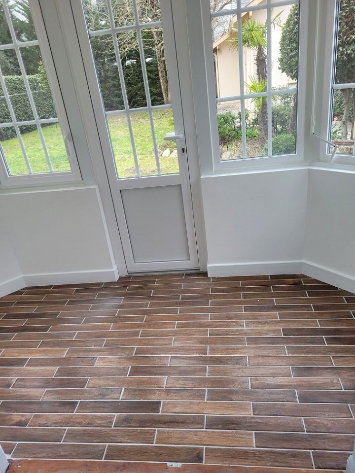 Véranda blanche avec un sol en carrelage