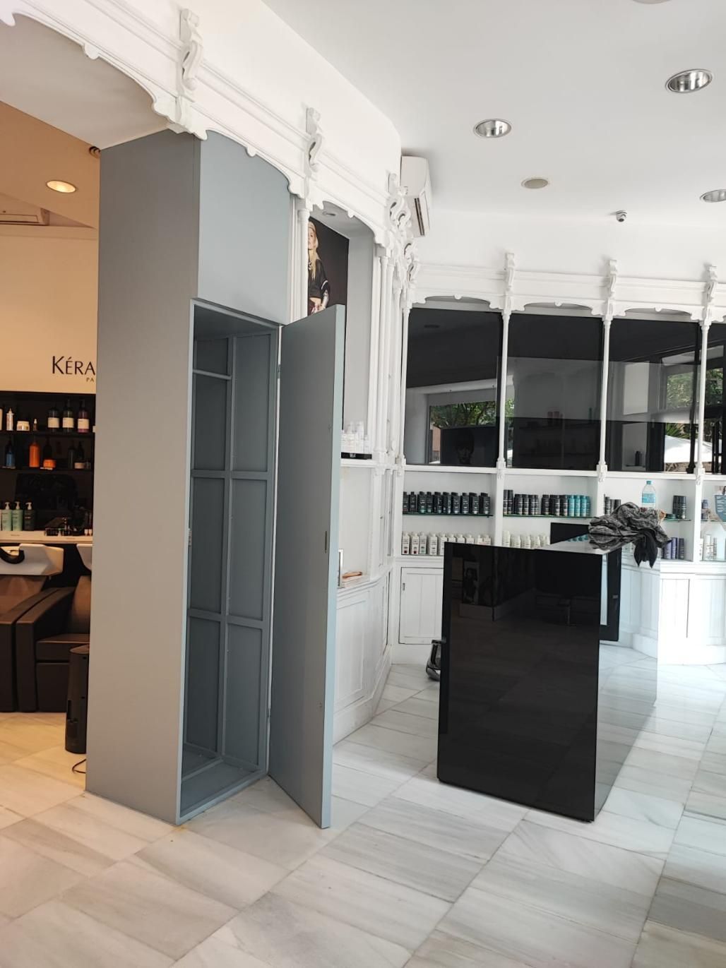 Armario de almacenaje de metal gris con puerta abierta en salón.