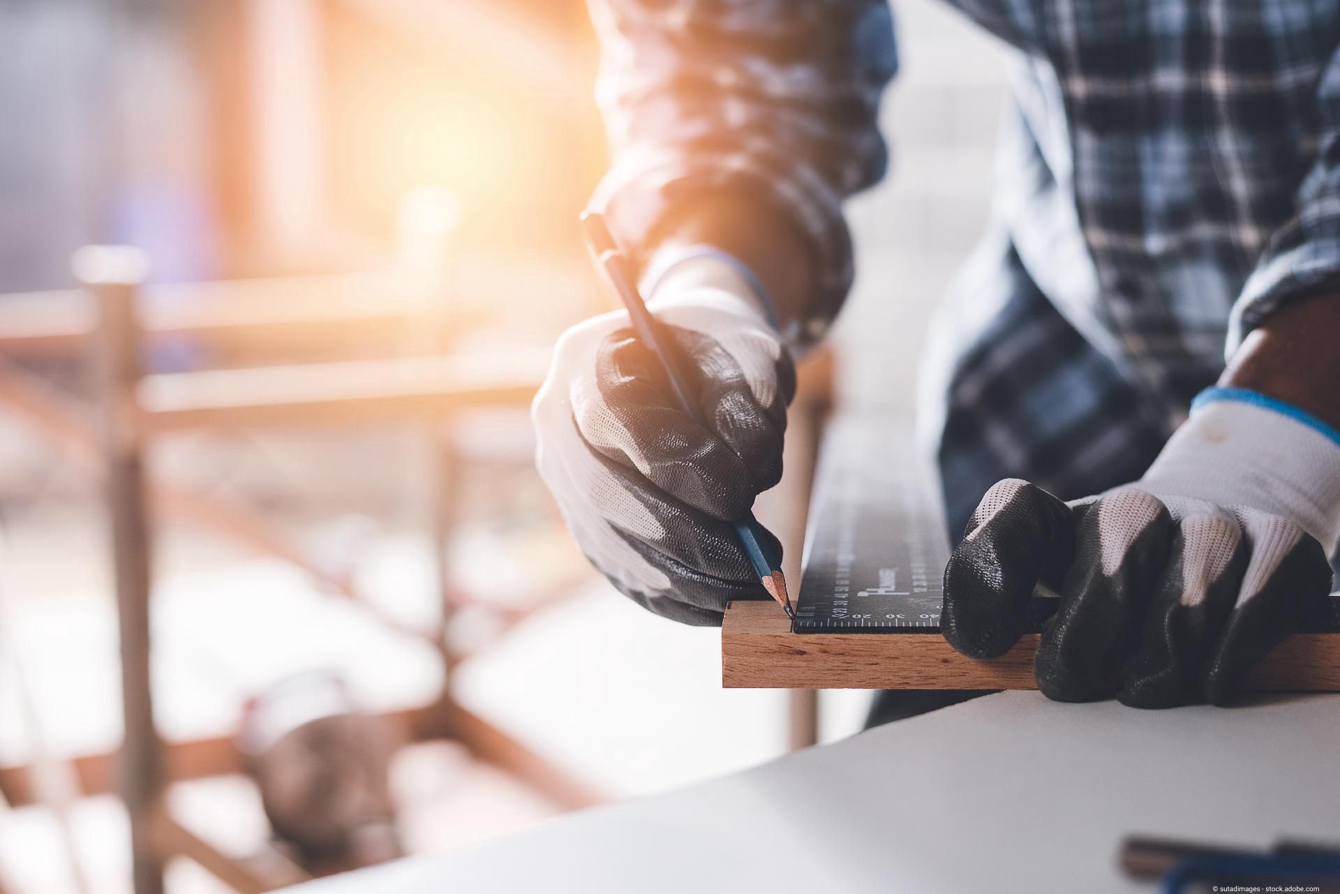 Handwerker misst Holz aus