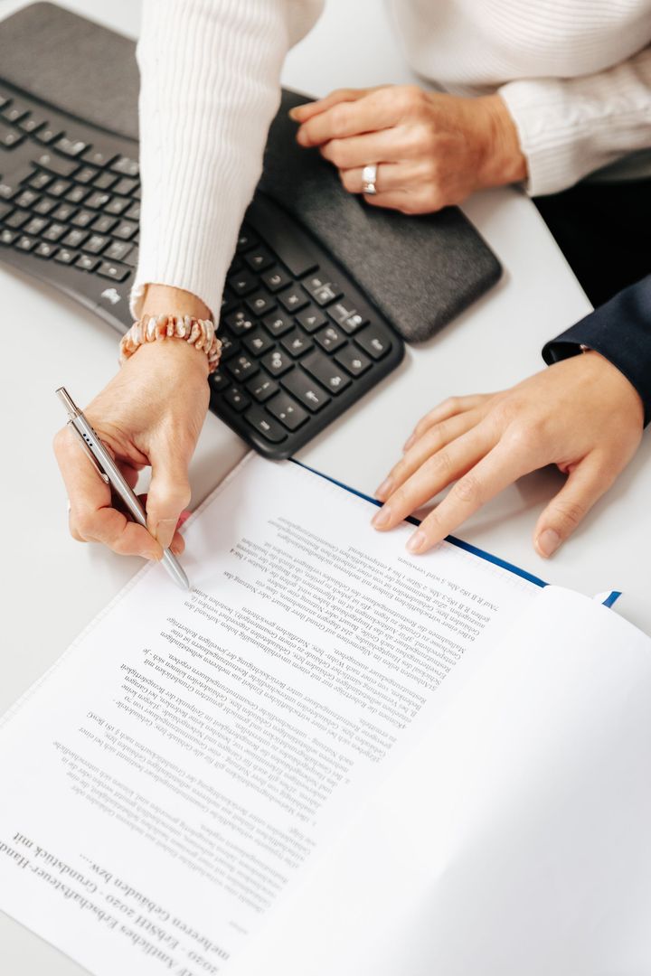 Geschäftstreffen: Personen analysieren in einer Büroumgebung Diagramme und Grafiken auf Laptops und Papier.