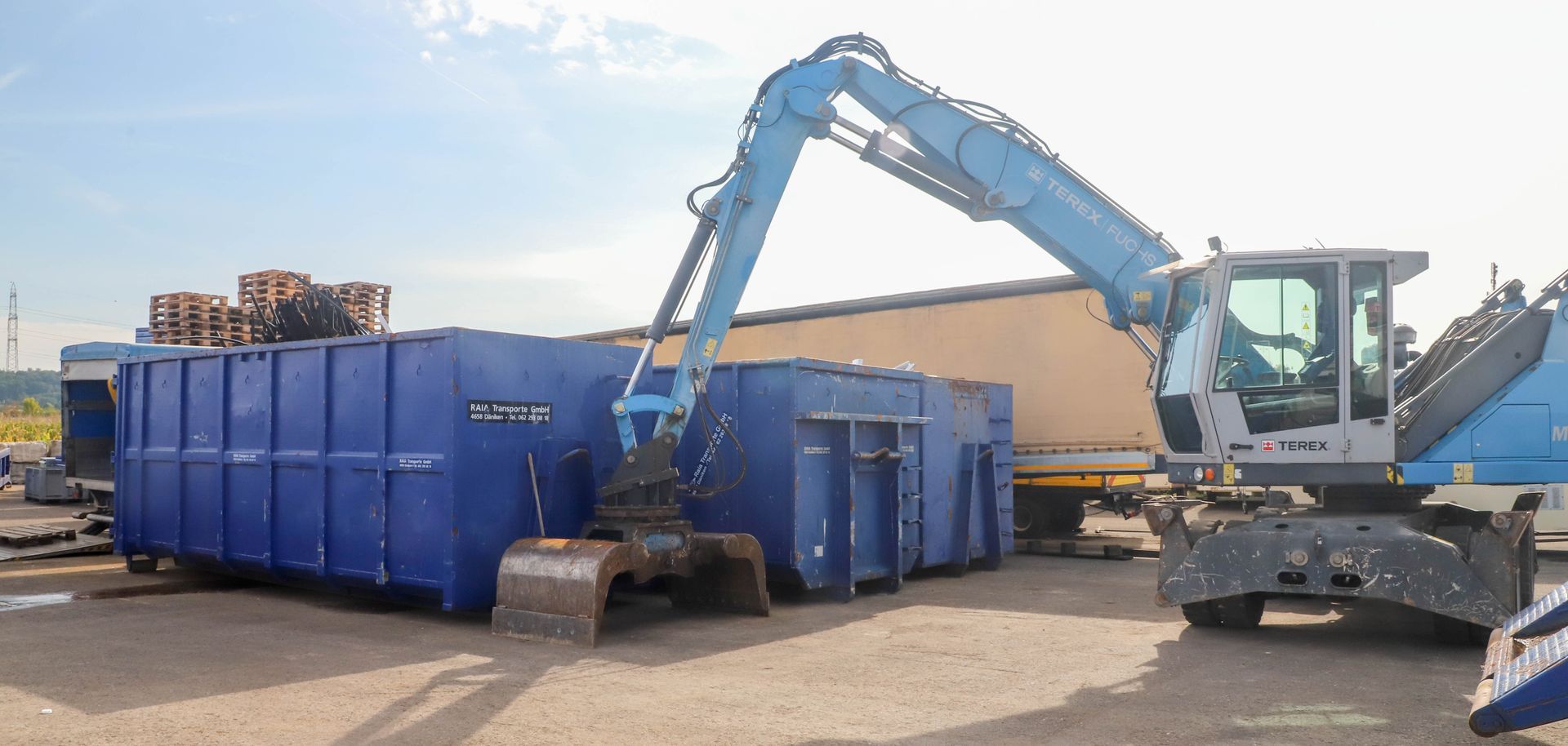 Eine Strassenkehrmaschine sammelt Laub und Schmutz von der Strasse. Der Fahrer trägt orangefarbene Schutzkleidung.