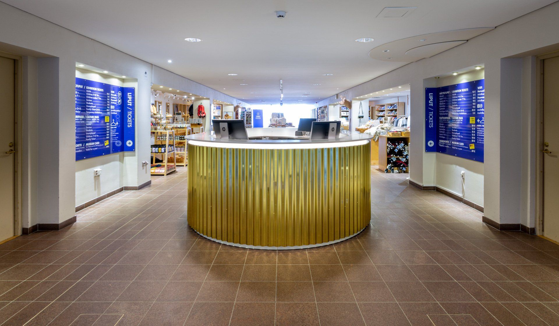 Museomyymälän ovaali palvelutiski. Pintamateriaali aaltopintainen messinkipelti. 