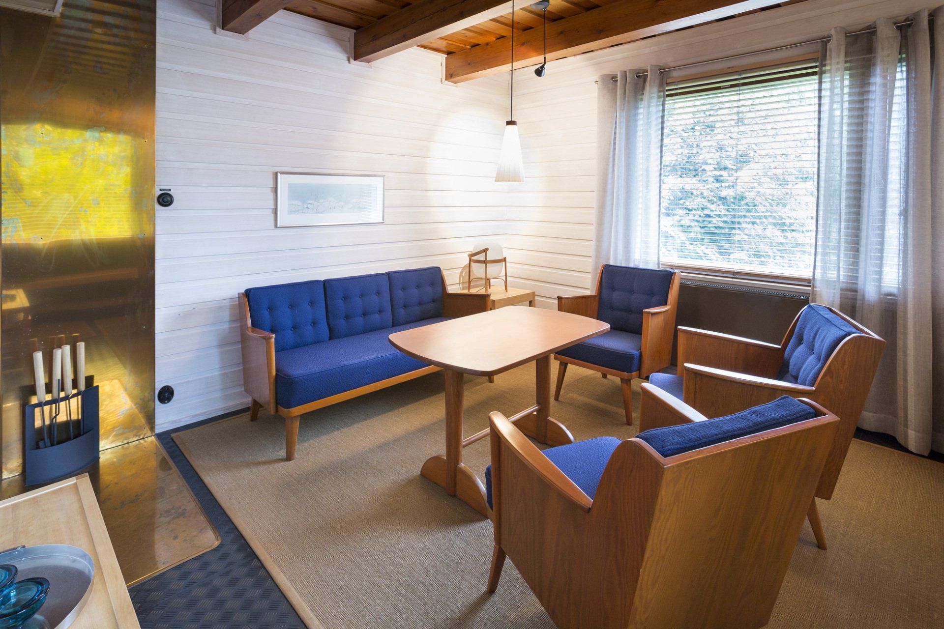 Edustustilojen takkahuoneen sisustus. Vanha puinen sohvaryhmä. 