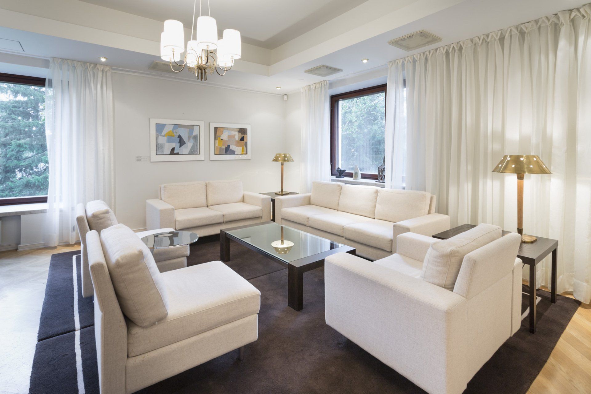 Edustustilojen olohuoneen sohvaryhmä. Pöytävalaisimet Innolux Senator. 