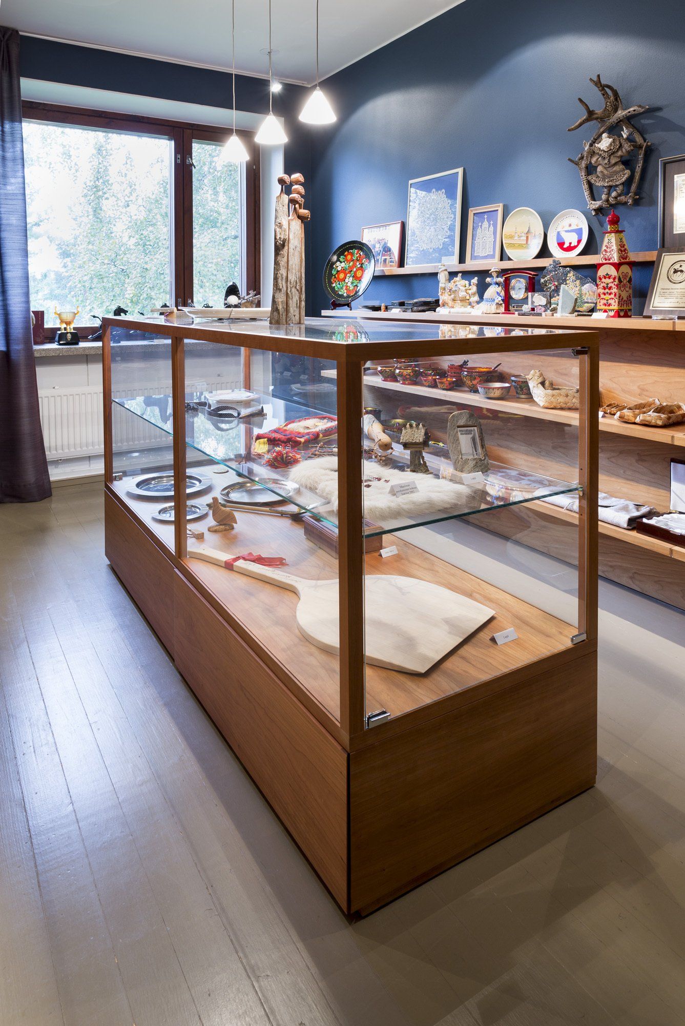 Myymälävitriini. Lasihyllyt ja puinen kehä. 