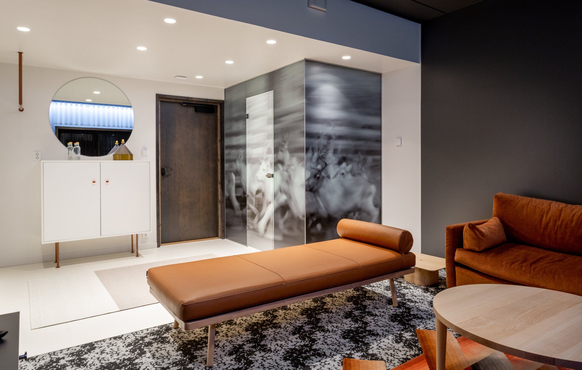 Hotelli Lapissa. Kylpyhuoneen lasiseinässä teippaus. Kuviollinen kokolattiamatto. Daybed Hakola Nap.