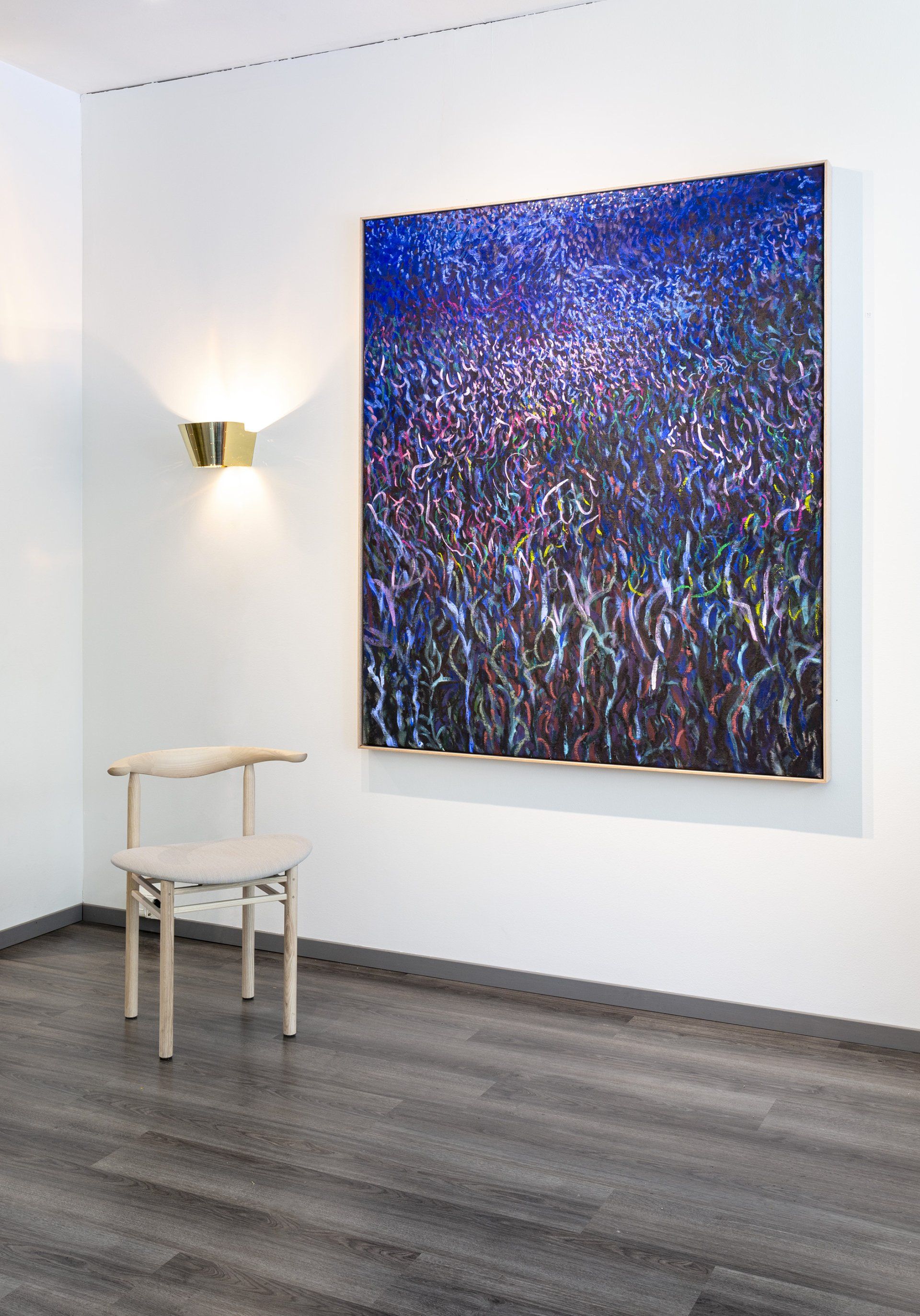 Seinällä Eemil Karilan taulu ja Gubi Tynell messinkivalaisin. Edessä tuoli Nikari Linea RMT3. 