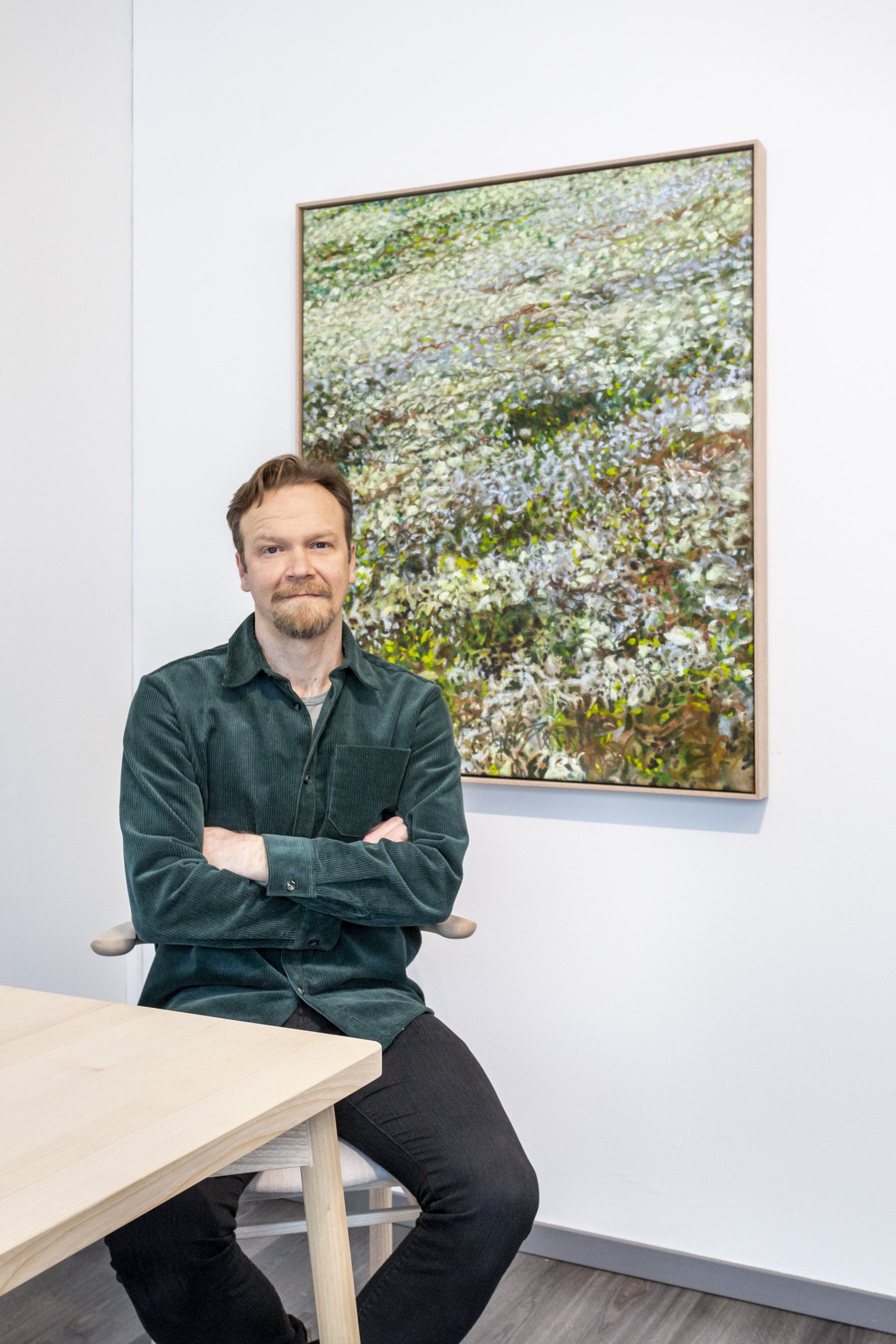 Eemil Karila henkilökuva. Taustalla taulu. 