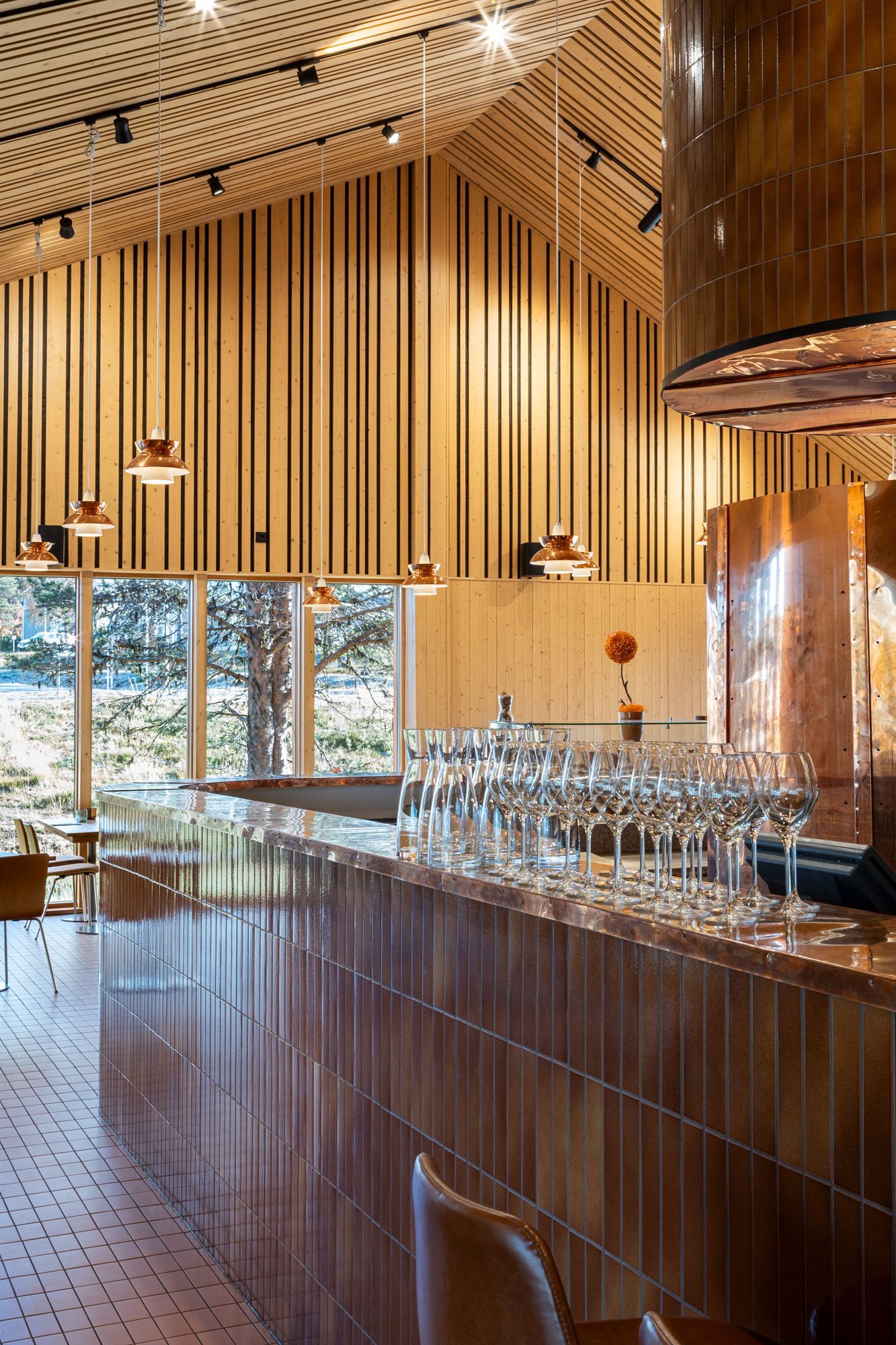 Kupari ravintolan sisustuksessa. Kupariset riippuvalaisimet Louis Poulsen Doo-Woop. Baaritiskin kuparitaso.