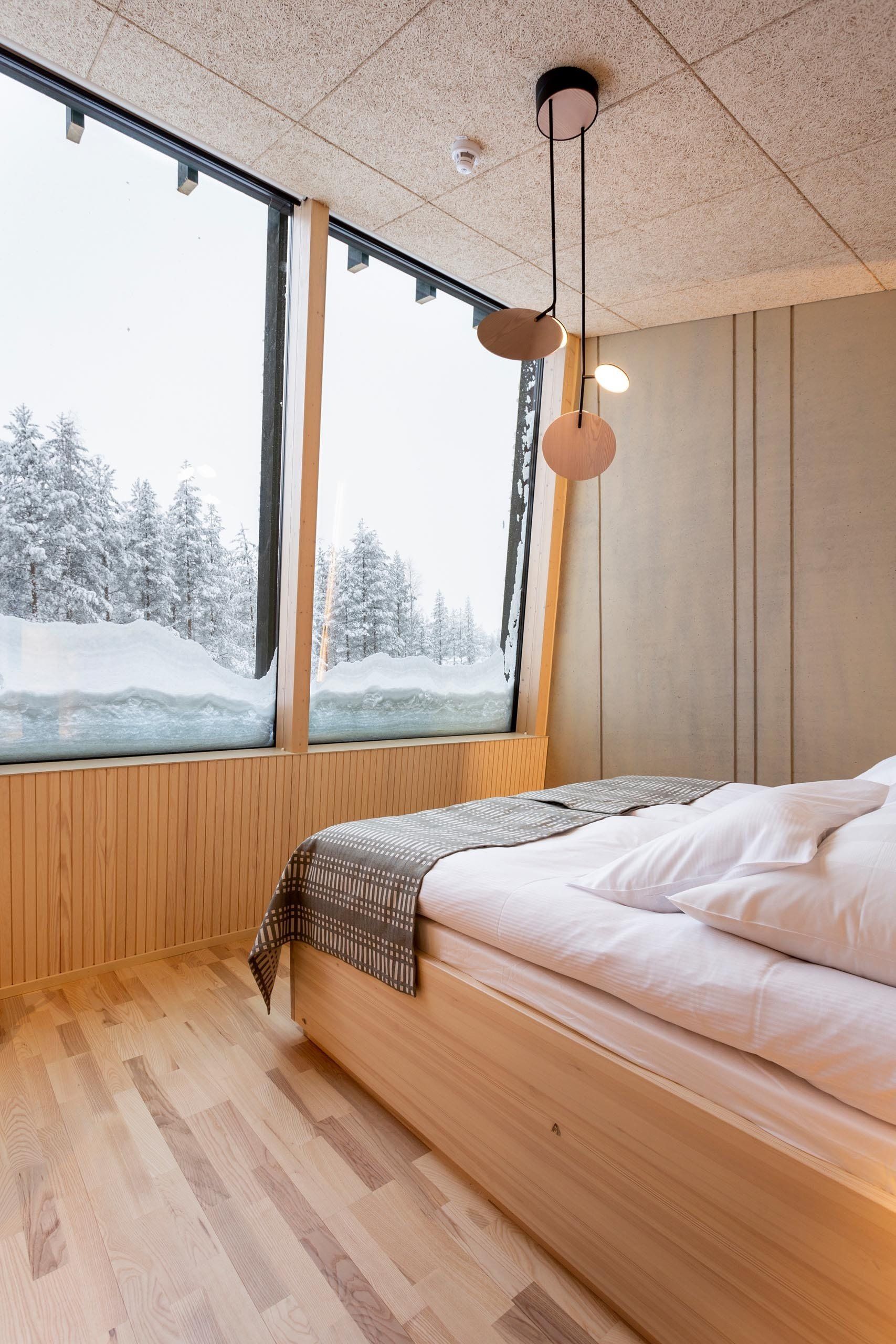 Luminen maisema hotellihuoneesta. Sängyllä päiväpeitto Johanna Gullichsen Nereus. 