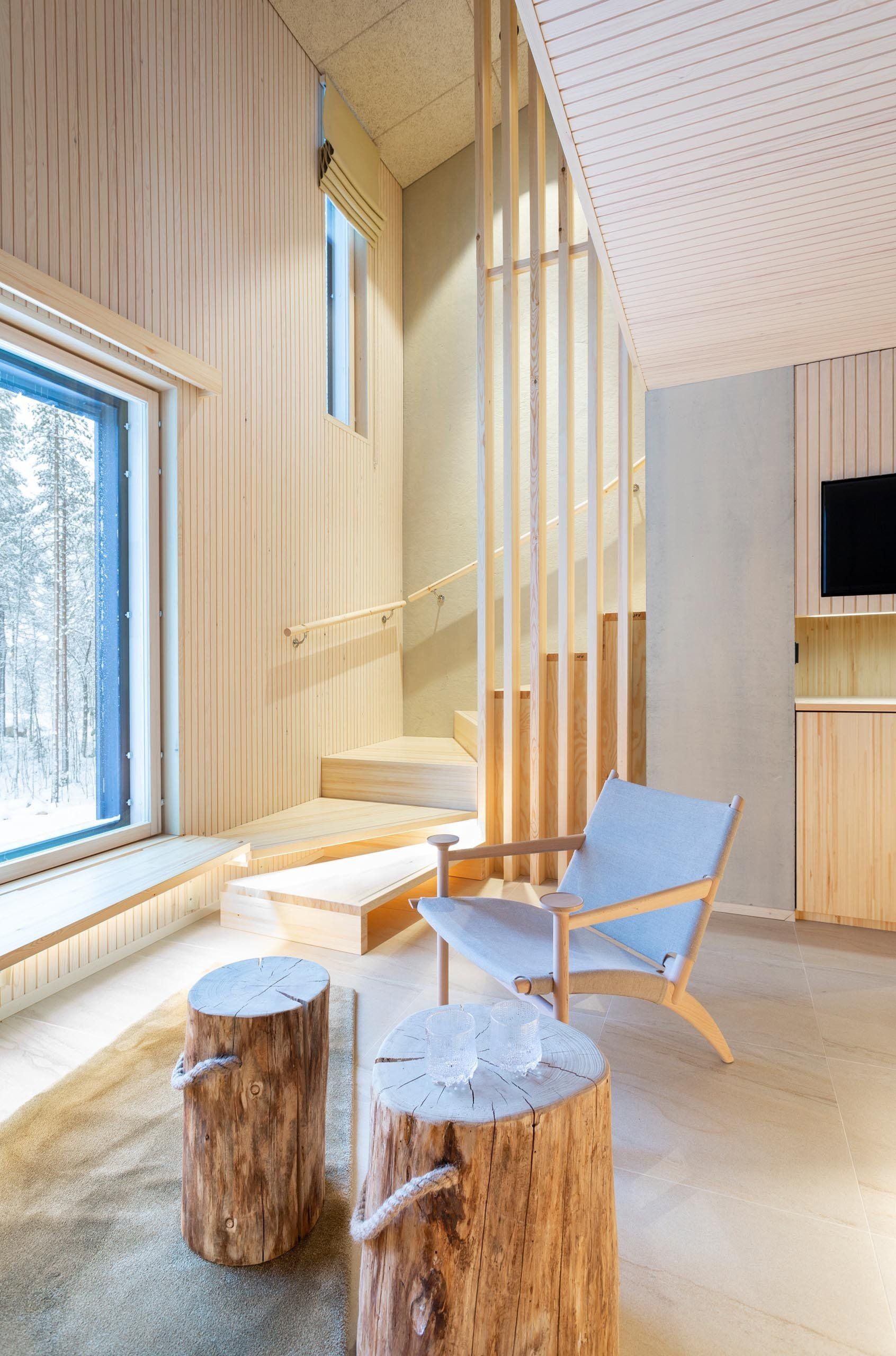 Kaksikerroksinen hotellihuone lapissa. Pintamateriaalit mänty. Ikkunanäkymä lapin luontoon. 