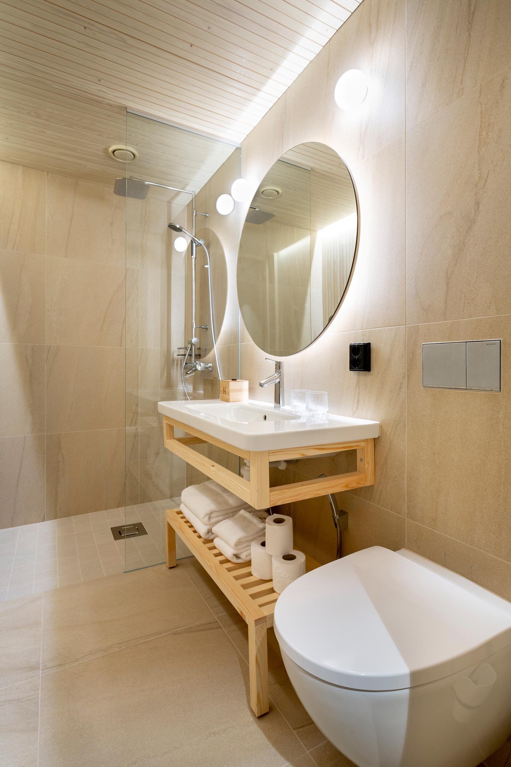 Hotellin kylpyhuone. Puinen allaskaluste. Isot 60x60cm laatat.