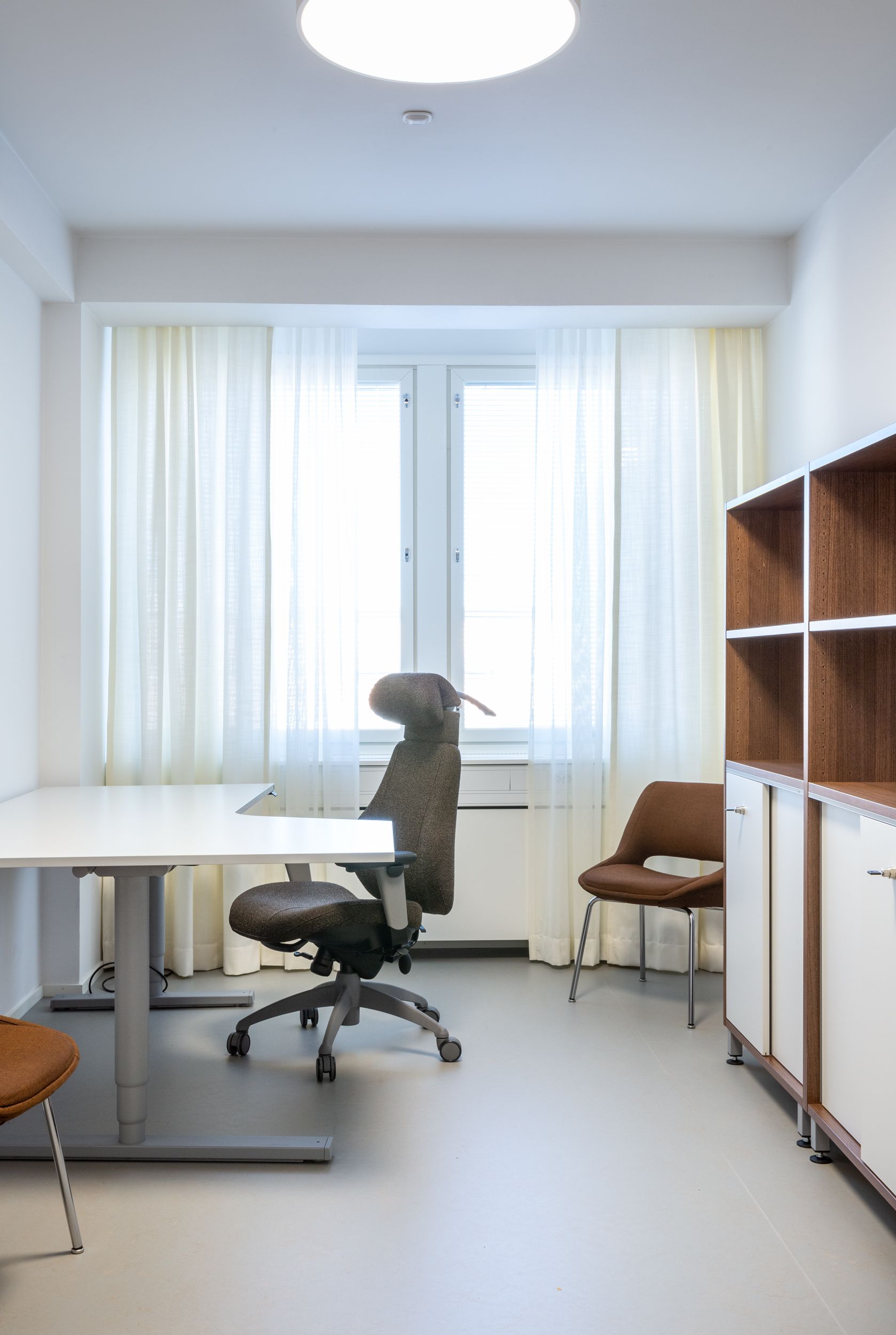 Työhuoneen työpiste. Sähköpöytä ja säädettävä työtuoli. 