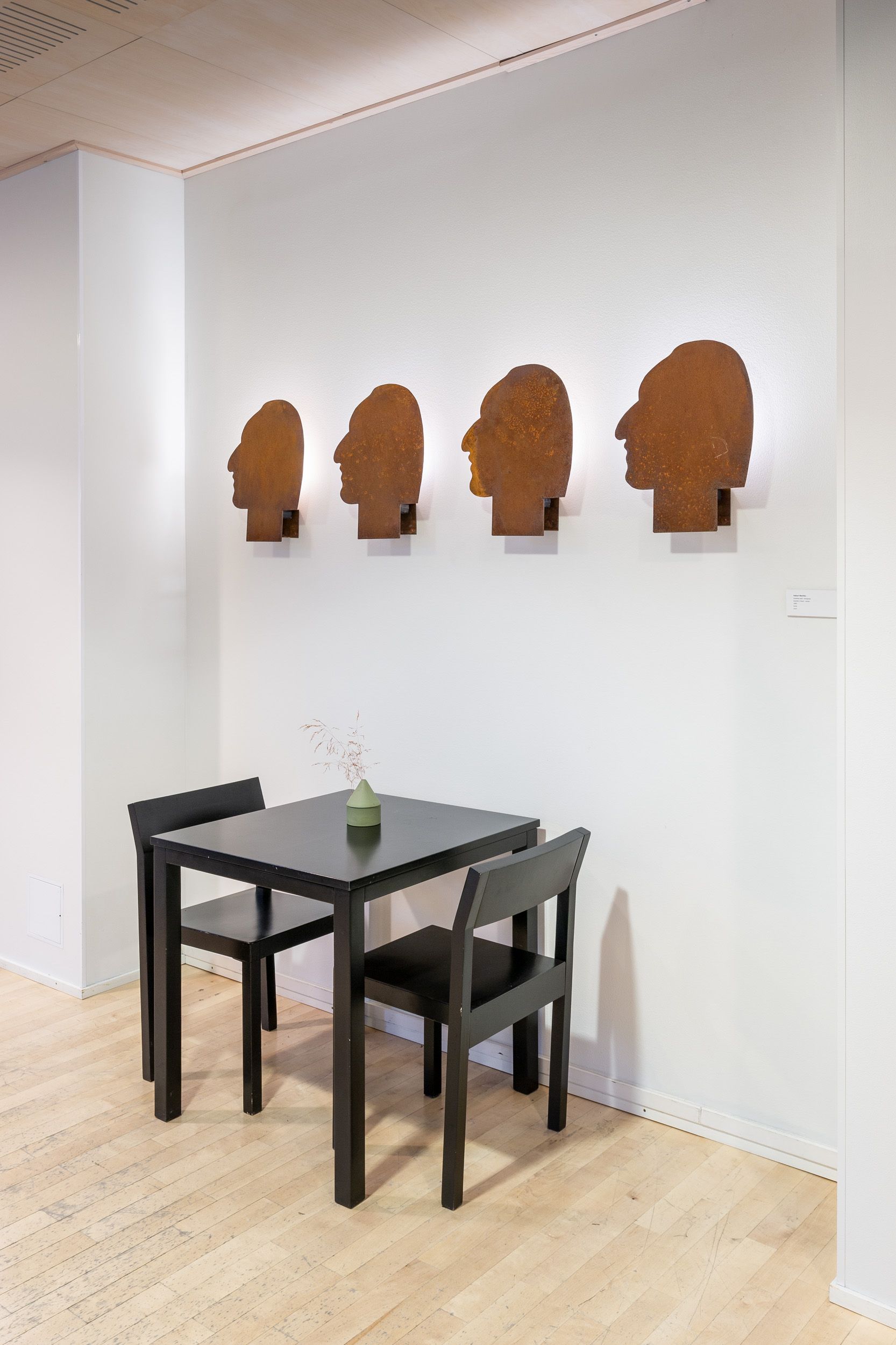 Rovaniemen taidemuseon kahvila-ravintola. Pöytäryhmä ja seinällä taidetta. 