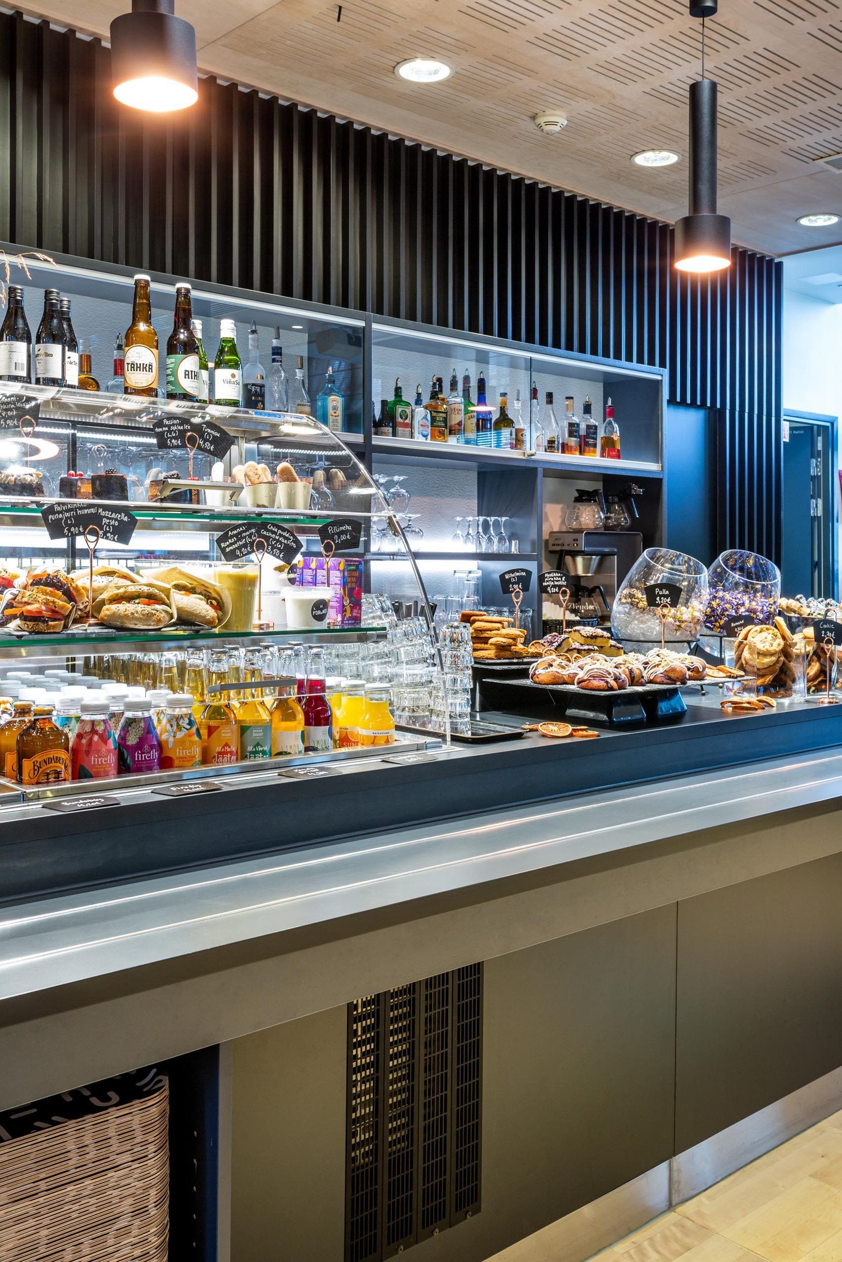 Kahvilan kassalinjasto - tuotteiden esillepano. Valaistu lasivitriini. 