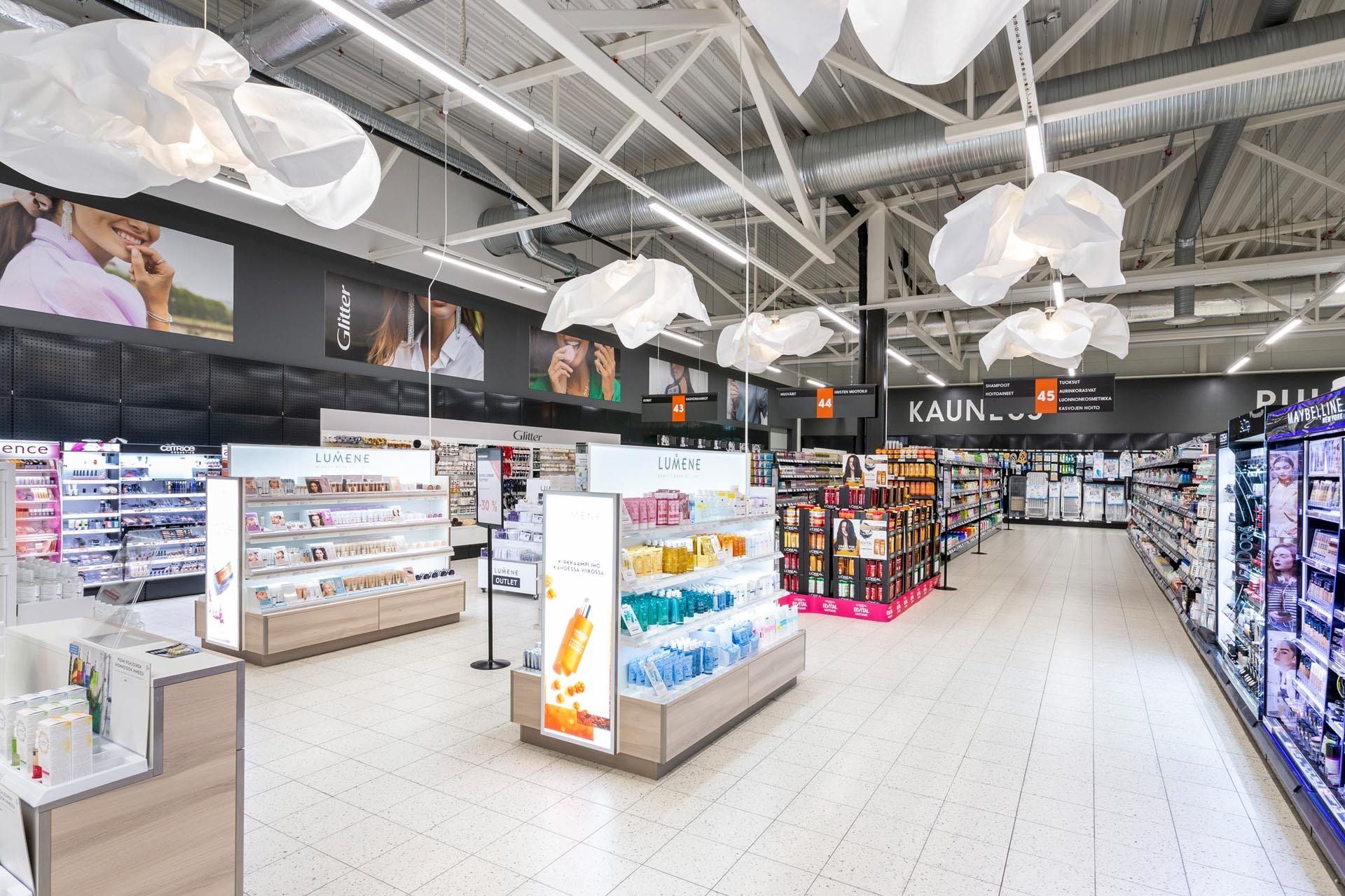 Hypermarketin Lumene meikkiosaston suunnitelma. Pilvenmuotoiset valaisimet Vivero Tollo