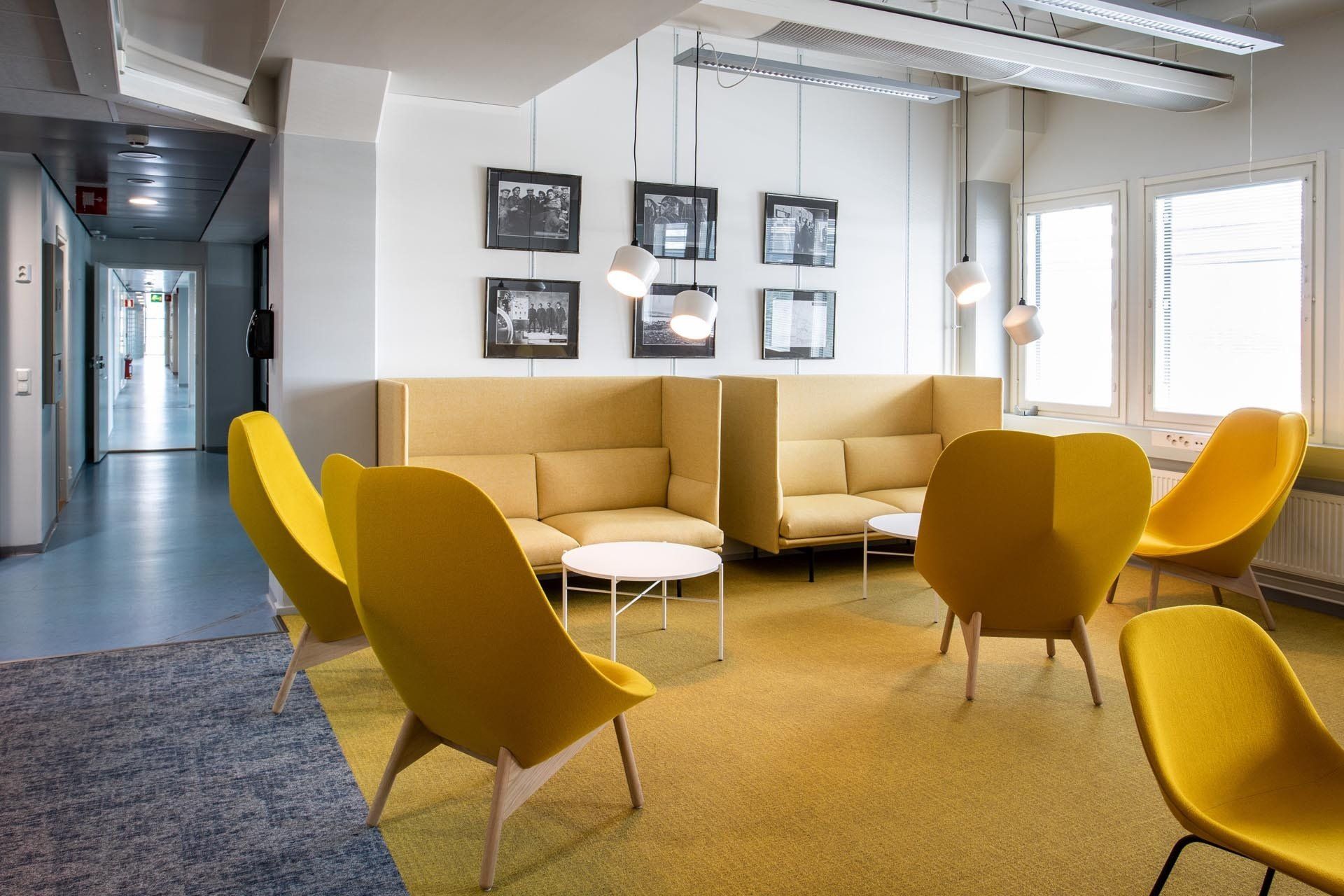 Toimistotilan lounge. Keltaiset korkeaselkänojaiset sohvat Muuto Outline ja nojatuolit Hay Uchiwa.