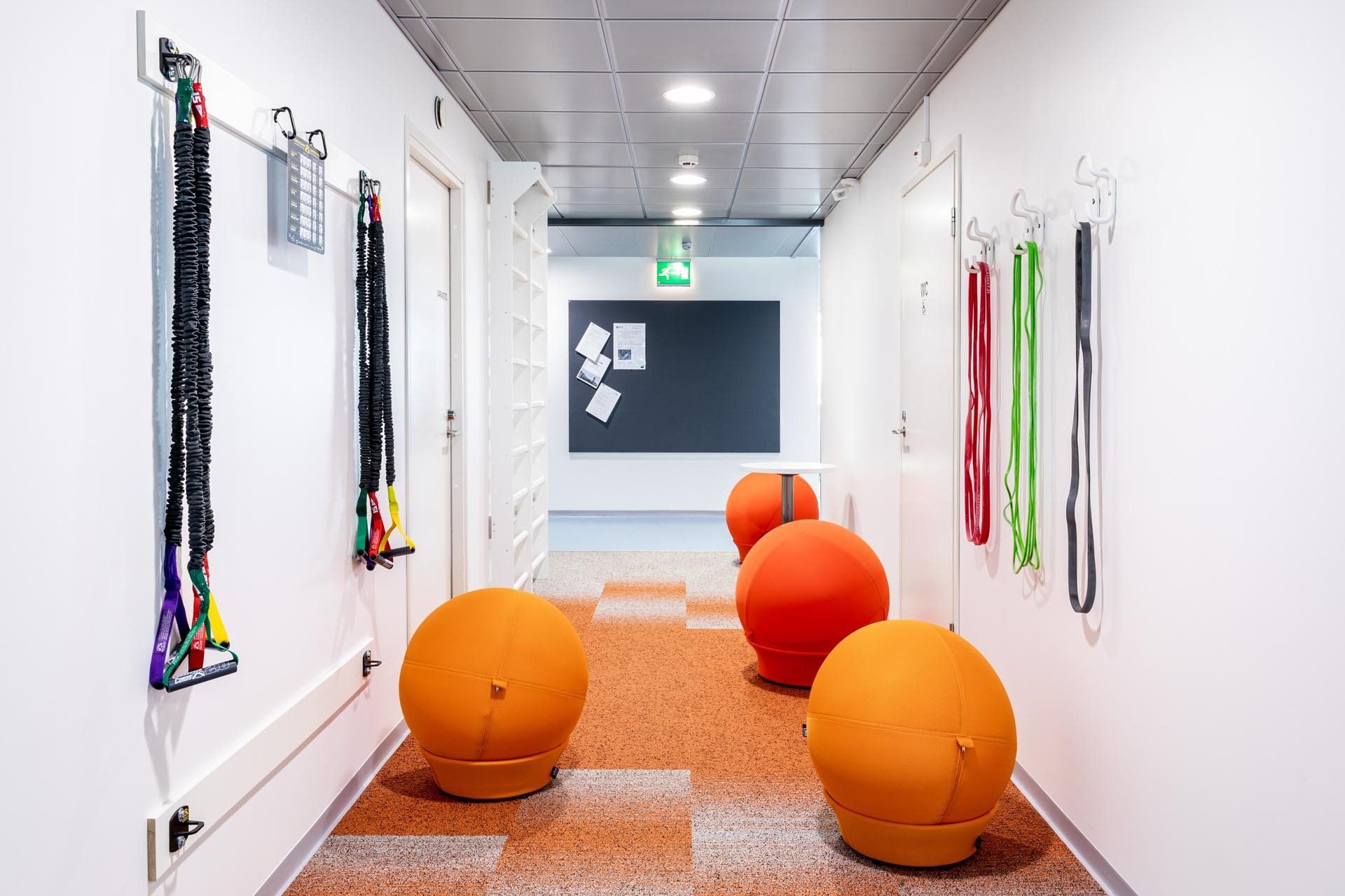 Hyvinvointia toimistotiloissa: kuntoiluvälineet käytävällä. Jumppapallot Lina Frozen Ball. Kokolattiamatto Desso Fuse.
