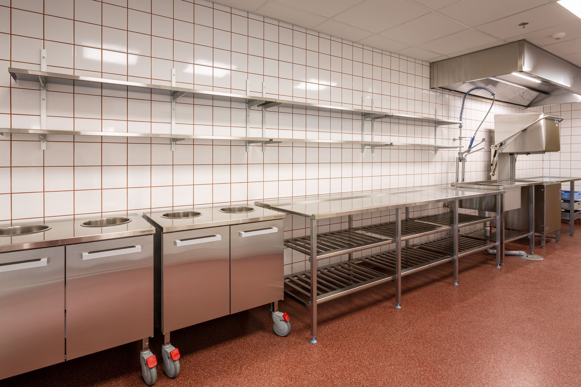 Laitoskeittiön astianpalautuspiste ja tiskilinjasto. Metos ammattikeittiölaitteet ja rst-kalusteet. Värillinen sauma.