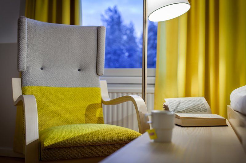 Keltainen hotellihuone. Artek nojatuoli 401. 