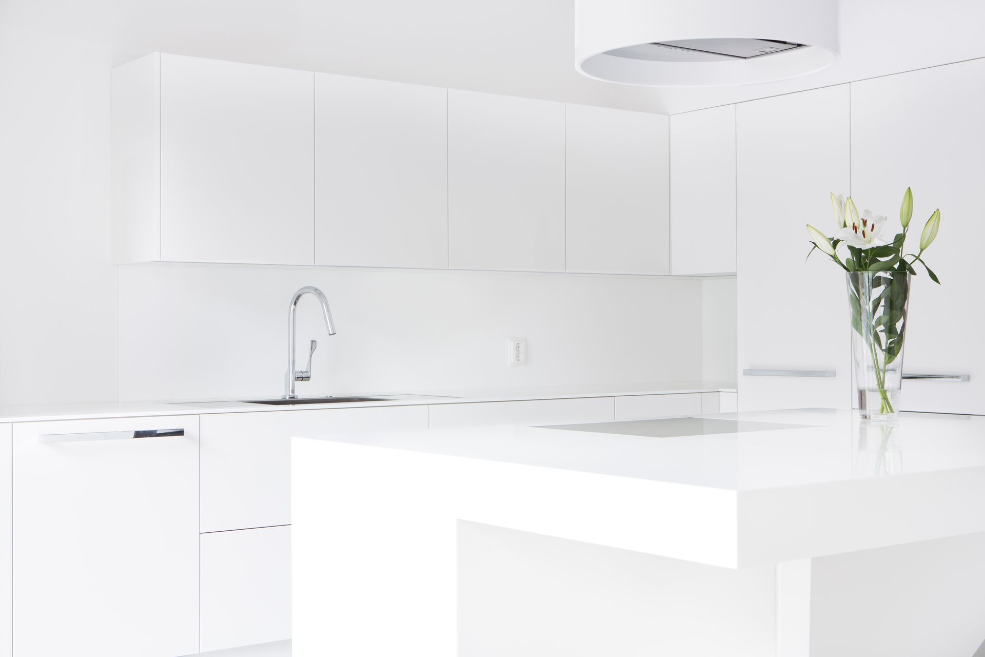 Valkoinen moderni keittiö ja muotoiltu saareke puusepäntyönä. 