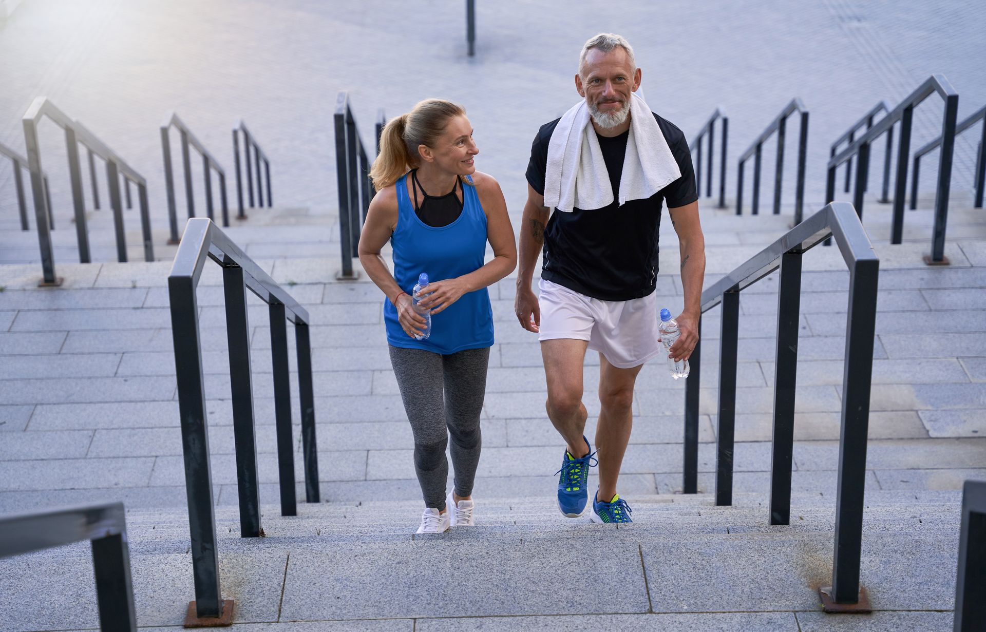 Un couple en tenue de sport qui monte des escaliers