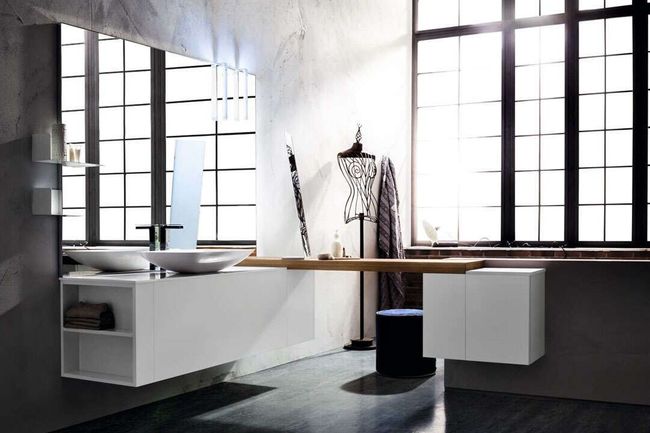 Salle de bains moderne blanche avec baignoire îlot, grandes fenêtres et peignoir suspendu.
